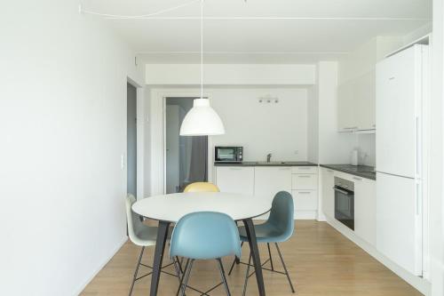 Una cocina blanca con una mesa y sillas blancas. en Beautiful 1-BR w a balcony by Odense harbour - 82, en Odense