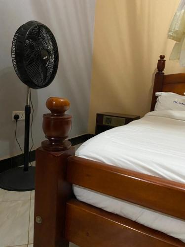 ein Schlafzimmer mit einem Ventilator neben einem Bett in der Unterkunft Nilevic Guest House Entebbe in Entebbe