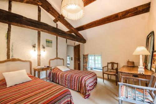 - une chambre avec 2 lits, un bureau et une table dans l'établissement La Grande Maison á Chanteuges, à Chanteuges