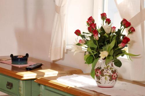 a vase filled with red and white flowers on a table at Stoffbauer GmbH in Graz