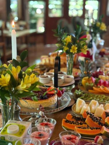 a long table with a buffet of food and desserts at Pousada Cerejeiras in Monte Verde