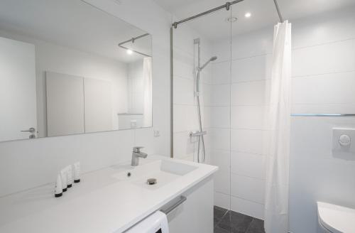 Un baño blanco con lavabo y ducha en Modern spacious 2-BR by Odense harbour - 91, en Odense