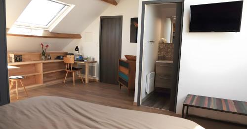 Un dormitorio con una cama y un escritorio y una ventana. en Chambres D'hôtes Le Palmier, en Saint-Michel-Mont-Mercure