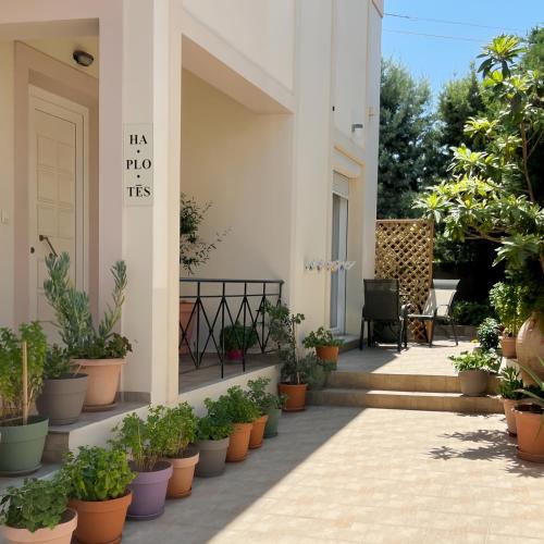 una casa con piante in vasi sul portico anteriore di Haplotēs Rhodes Apartment a Koskinou