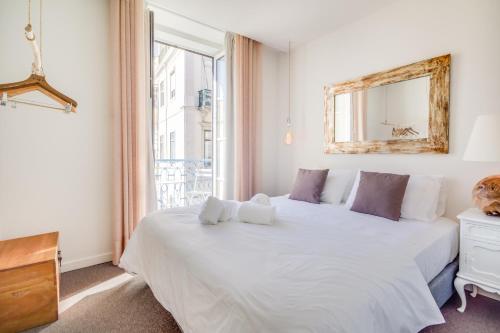 a bedroom with a large bed and a large window at Chiado 44 in Lisbon