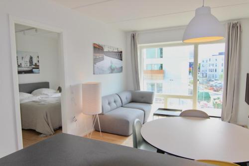 una sala de estar con un sofá y una mesa en Beautiful 2-BR w a balcony by Odense Harbour - 125, en Odense