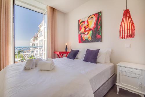 a bedroom with a large white bed and a large window at Chiado 44 in Lisbon