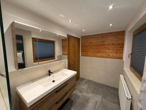 a bathroom with a white sink and a mirror at Apartment Tirol #Spielanger Hof# in Weer