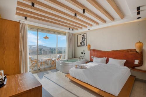 1 dormitorio con cama, bañera y mesa en ONE GATE Pyramids View INN, en El Cairo