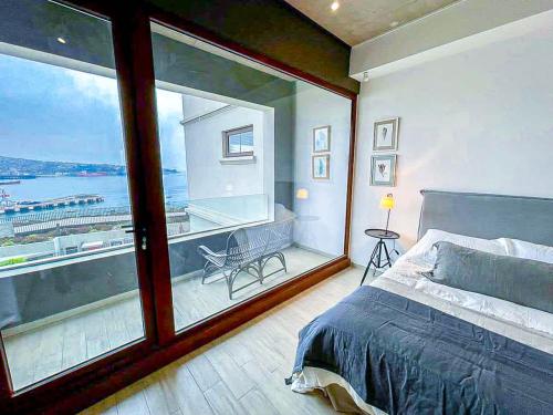 una camera da letto con una grande finestra con vista sull'acqua di HOM I Duplex en Mejor Vista de Valparaiso y Parking a Valparaíso