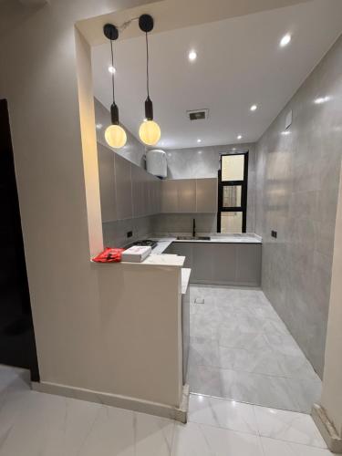 a kitchen with a counter and two lights on the ceiling at المعتلية in Riyadh