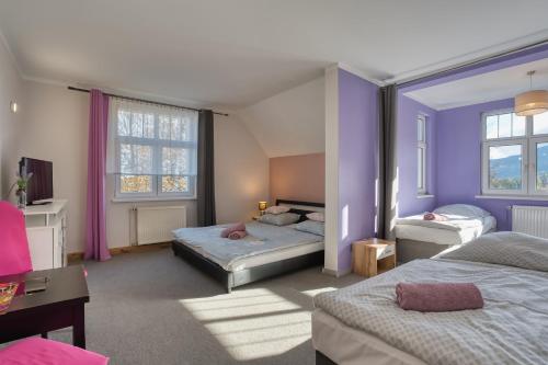 1 Schlafzimmer mit 2 Betten und lila Wänden in der Unterkunft Lawendowy Dworek in Karpacz