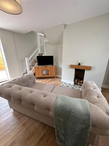a living room with a couch and a television at Cosy two bedroom cottage in Castle Donington