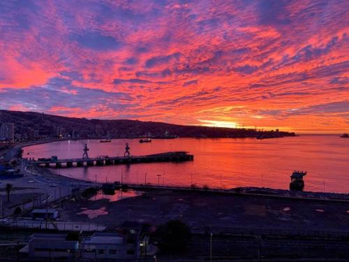 una puesta de sol sobre una gran masa de agua en HOM I Duplex en Mejor Vista de Valparaiso y Parking, en Valparaíso