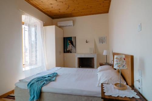 Un dormitorio con una cama grande y una chimenea. en Αγία Κυριακή Traditional Guesthouse, en Ayía Kiriakí