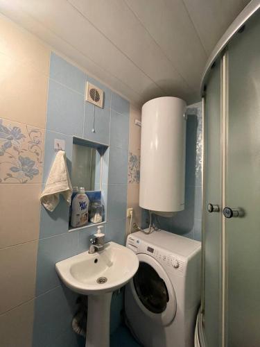 a small bathroom with a washing machine and a sink at CenterHouse1 in Karakol