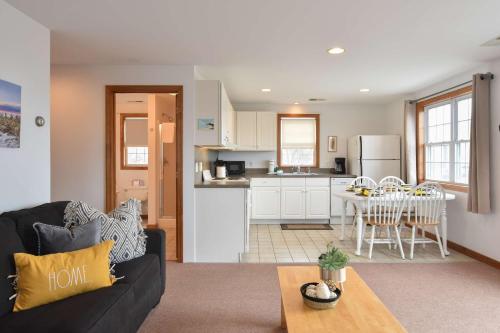 a living room and kitchen with a couch and a table at 12215 - Beautiful Views of Cape Cod Bay Access to Private Beach Easy Access to P-Town in Truro
