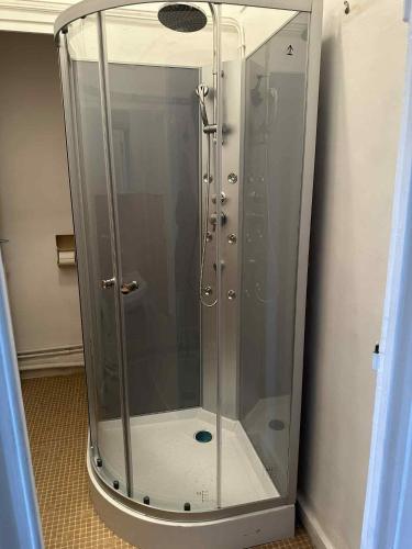 a shower stall with a glass door in a bathroom at Studio 2 personnes in La Bourboule
