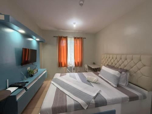 a bedroom with a large bed and a television at Standard Room at 8 Spatial by Forever-mc Condotel 8335 in Davao City