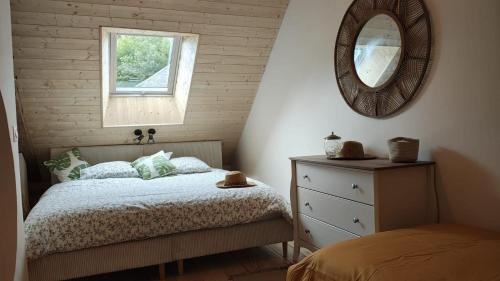 a bedroom with a bed and a mirror and a dresser at Spacieuse maison de vacances in Sorges