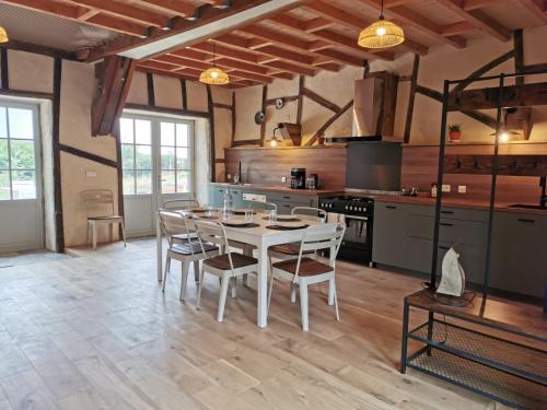 a kitchen with a table and chairs in a room at Spacieuse maison de vacances in Sorges