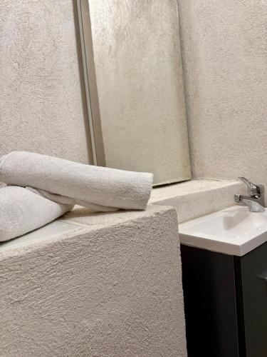 Un baño con toallas en un mostrador junto a un lavabo. en La Douceur du Fort - Parking, extérieur, vue, en Mercury