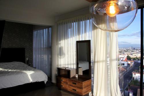 a bedroom with a bed and a mirror and a window at Penthouse with Glass Floor and Volcano View in Cholula