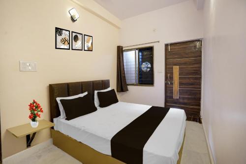 1 dormitorio con 1 cama y puerta con ventana en Hotel O Agrawal Inn, en Jabalpur