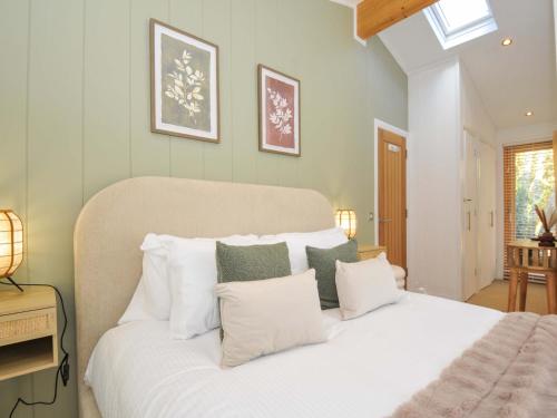 a bedroom with a large bed with white pillows at 6 Stonerush Valley in Looe