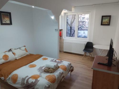 a bedroom with a bed and a desk and a window at Spital 1 camera etaj 2 in Târgu-Mureş