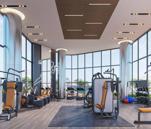 Un gimnasio con un montón de equipos de ejercicio y ventanas. en Super luxury apartment with stunning views in Tri-Zen Colombo 2, en Colombo