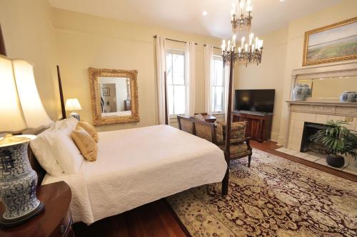 um quarto com uma cama e uma lareira em Foley House Inn em Savannah
