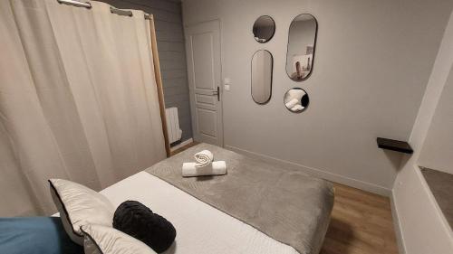 a bedroom with a bed with two mirrors on the wall at Appartement MVM Jacuzzi proche Saint-Malo in Plouër-sur-Rance