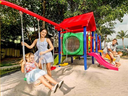 ボプートにあるHotel Ibis Samui Bophutの遊び場で遊ぶ女と子供2人