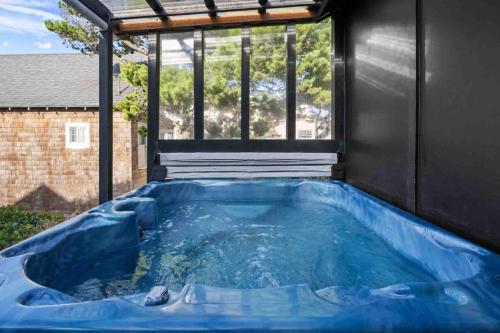 a hot tub in a backyard with a large window at Seabatical on The Strand in Manhattan Beach