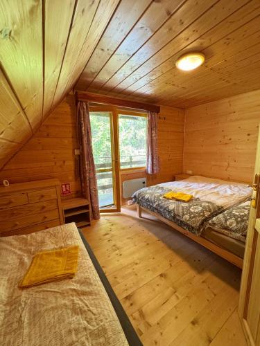 a bedroom with two beds in a log cabin at Chata U Hýka in Ludvíkov