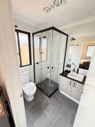a bathroom with a toilet and a shower and a sink at The Margs Hideaway Ensuite in Margaret River Town