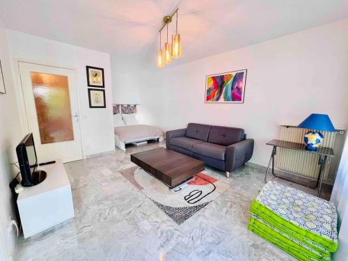 una sala de estar con un sofá y una mesa en L'Eden Apt 4 Prs, clim, parking, 300 m des plages, en Antibes