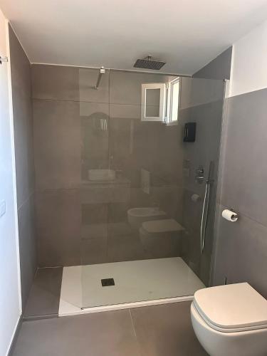 a bathroom with a toilet and a glass shower at Royal View Apartment in Caserta