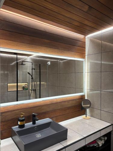 a bathroom with a sink and a mirror at Stylish and cozy apartment in Rovaniemi
