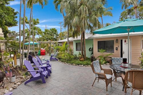 een patio met paarse stoelen en een tafel bij Coastline Comfort in Key West