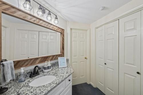 拉科尼亚Lakeview Escape - Beach Access & Balcony Views的带水槽和大镜子的浴室