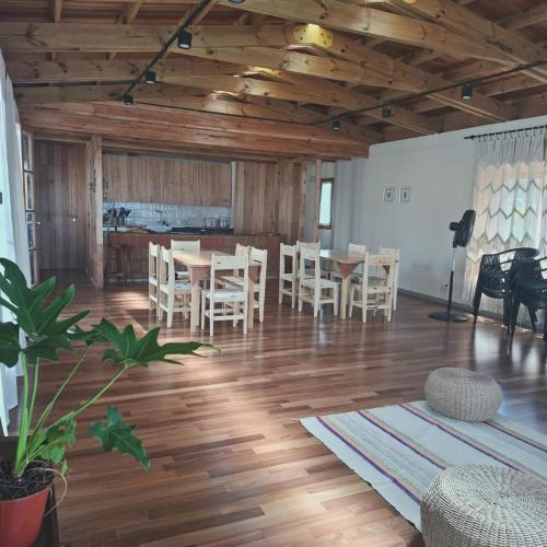 a dining room with wooden floors and a table and chairs at Hostería Casa Angirû in Colonia Chapadmalal
