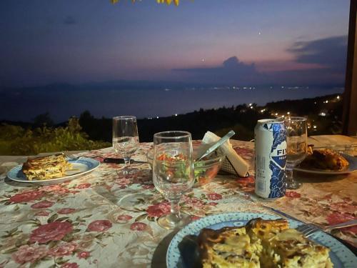een tafel met borden met eten en wijnglazen bij Holiday house afetes in Afétai
