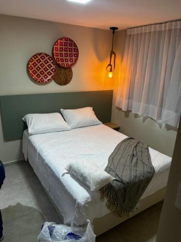 een slaapkamer met een bed met rode borden aan de muur bij Max Suites block A, apartment 002 in Praia dos Carneiros