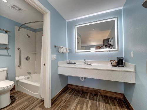 um banheiro com uma pia, uma banheira e um vaso sanitário em Ocean's Edge Hotel, Port Aransas,TX em Port Aransas