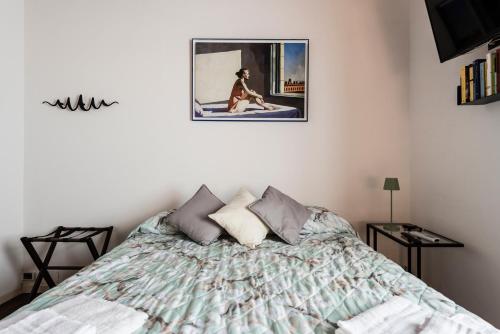 比萨Stanza San Francesco的卧室里有一张床，墙上挂着一幅画