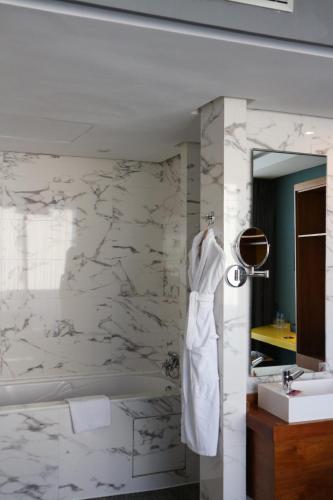 a white bathroom with a tub and a sink at Boutique Hotel Gauthier Restaurant Terrasse in Casablanca