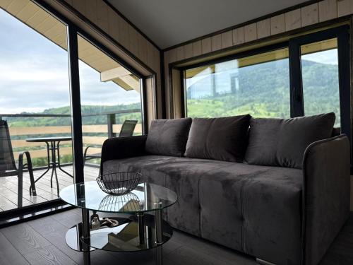 ein Wohnzimmer mit einer Couch und einem Glastisch in der Unterkunft Mountain soul hub in Krasnik