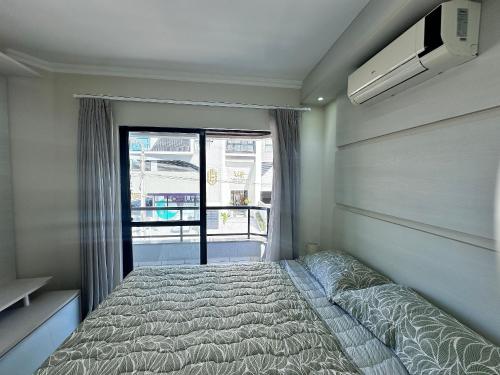 Un dormitorio pequeño con una cama y una ventana. en B484 - Apto 3 quartos perto do mar e com vista., en Bombas